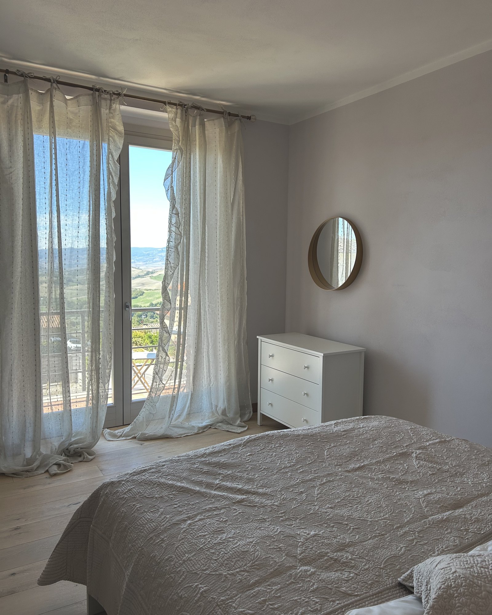 The master bedroom with balcony doors onto the hills